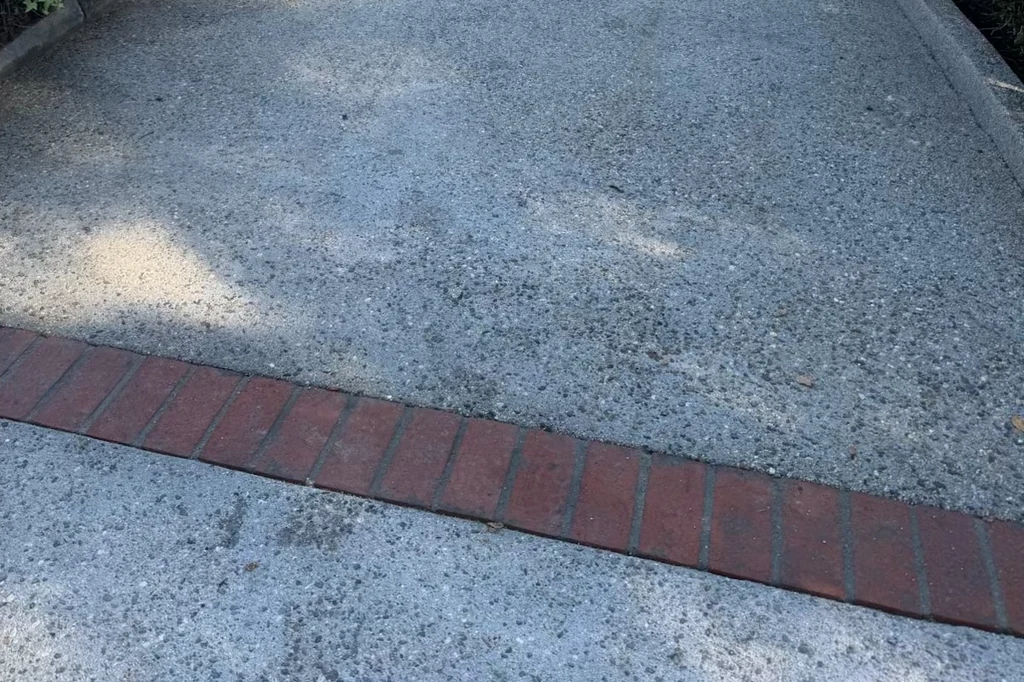 Exposed aggregate: washed back to the stone, against a red brick border