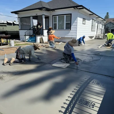 The crew finishing a fresh slab by hand, floats and knee boards down