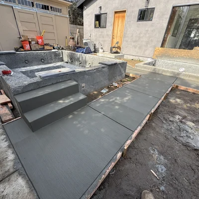 Formed concrete steps and a landing beside a finished slab