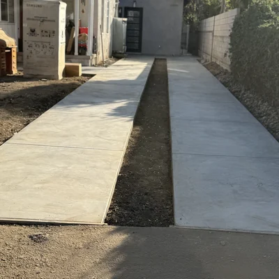 A long side-yard walkway poured between the house and the fence