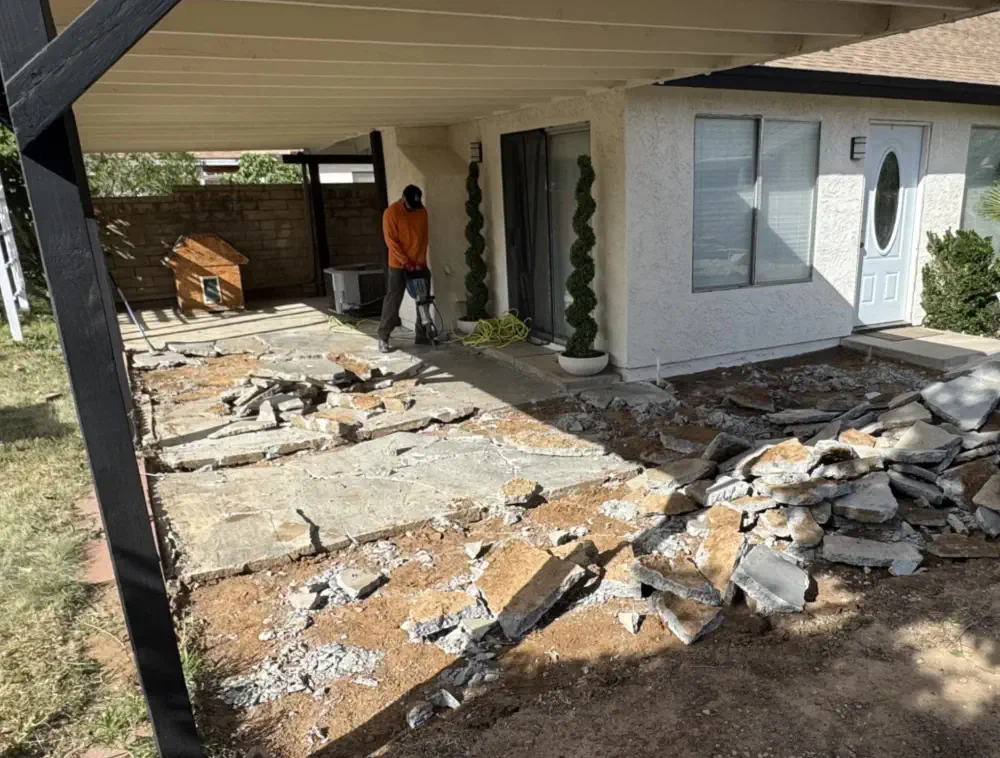 Day 0: the old patio slab broken out, rubble stacked on bare dirt under the covered patio
